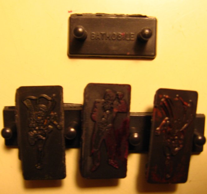 Photograph of six small plastic stamps with Batman characters.