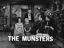 Still from a promo for The Munsters, showing the family seated on a couch.